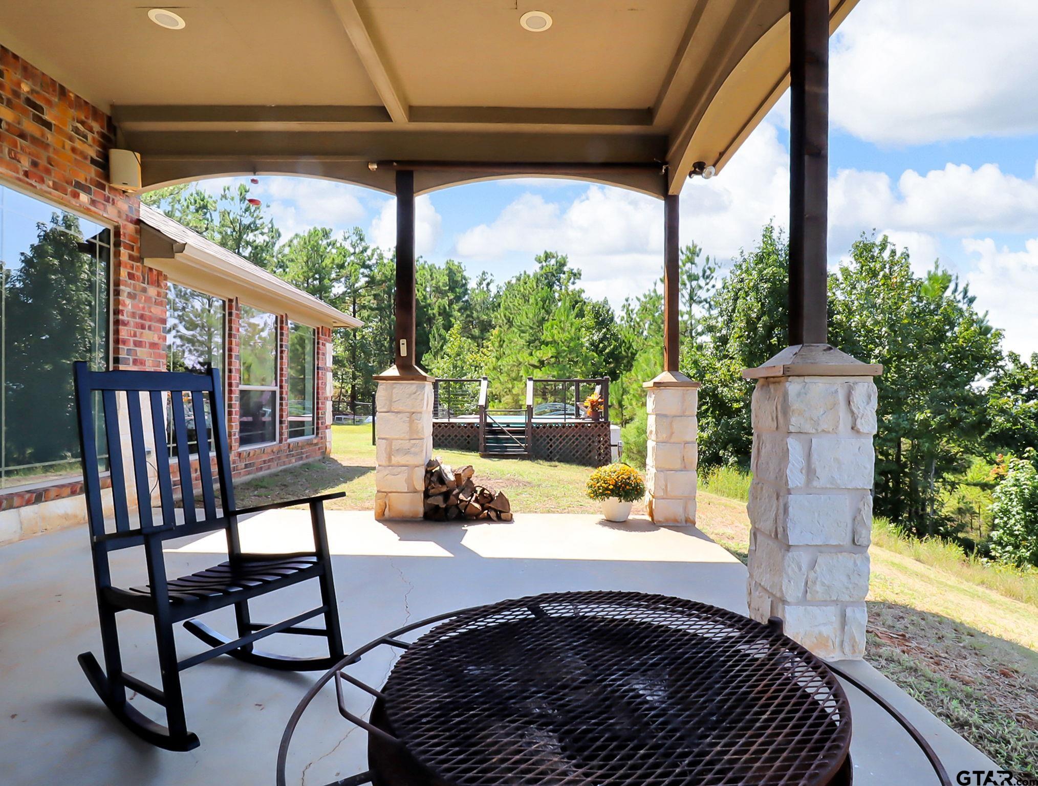 307 Roesch Road Hallsville, TX 75650 - Photo 33 of 40 a view of a patio with a table chairs and a backyard