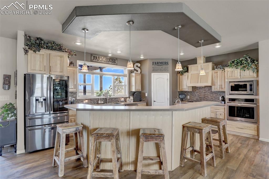 24335 Sweet Road Calhan, CO 80808 - Photo 14 of 39 a kitchen with stainless steel appliances kitchen island granite countertop a table chairs microwave and sink