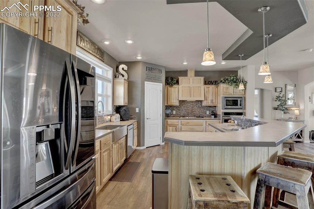 24335 Sweet Road Calhan, CO 80808 - Photo 15 of 39 a kitchen with kitchen island stainless steel appliances a sink stove and refrigerator
