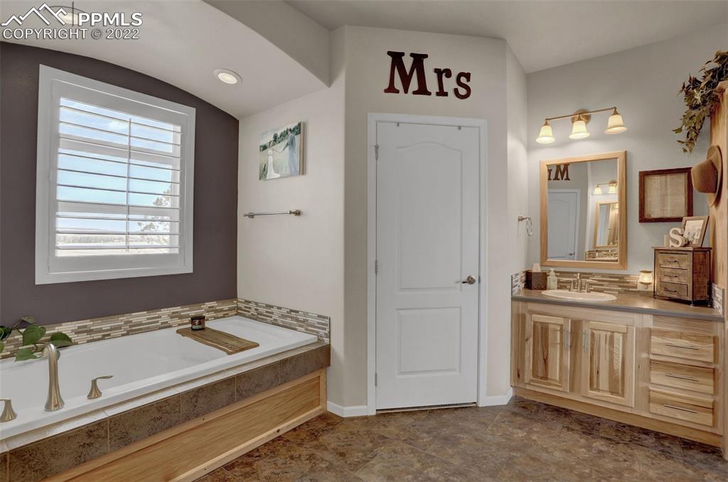 24335 Sweet Road Calhan, CO 80808 - Photo 26 of 39 a spacious bathroom with a granite countertop sink and a mirror