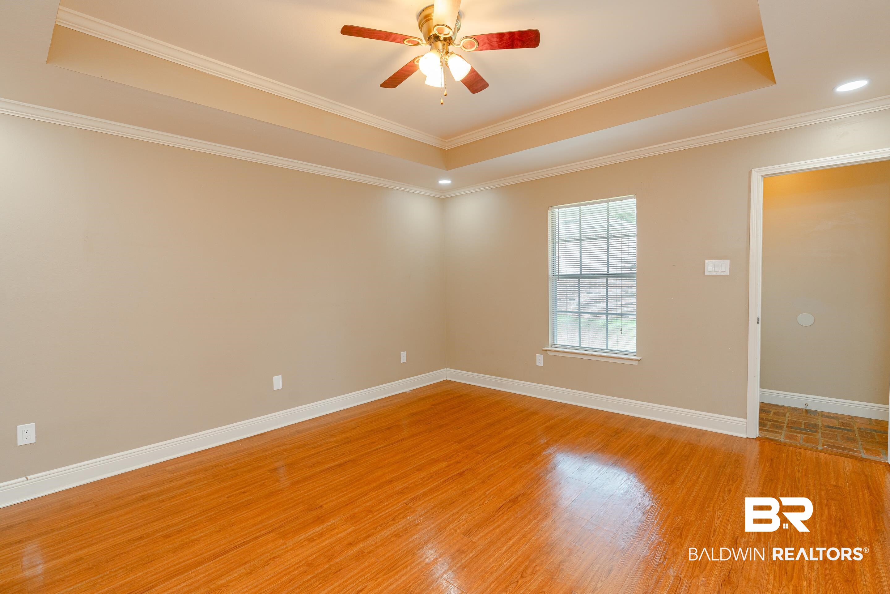 23 Old Mill Court Mobile, AL 36608 - Photo 19 of 37 Spare room featuring ceiling fan, light hardwood / wood-style flooring, a tray ceiling, and ornamental molding