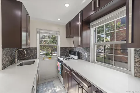 a kitchen that has a sink a stove and chairs