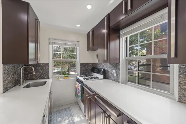 a kitchen that has a sink a stove and chairs