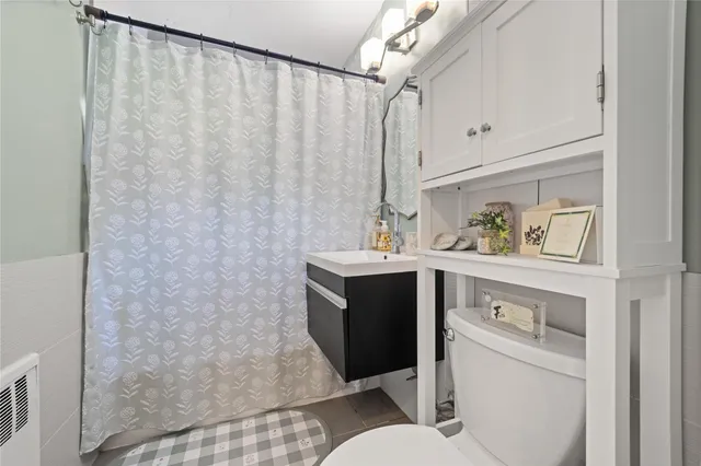 a bathroom with a sink vanity mirror and toilet