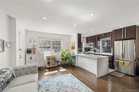 a living room with stainless steel appliances furniture and a window