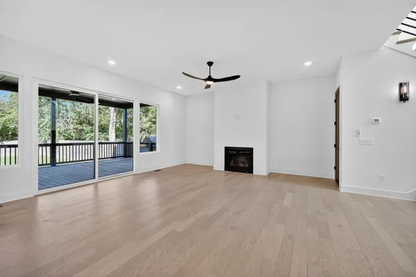 a view of an empty room with stairs and a ceiling fan