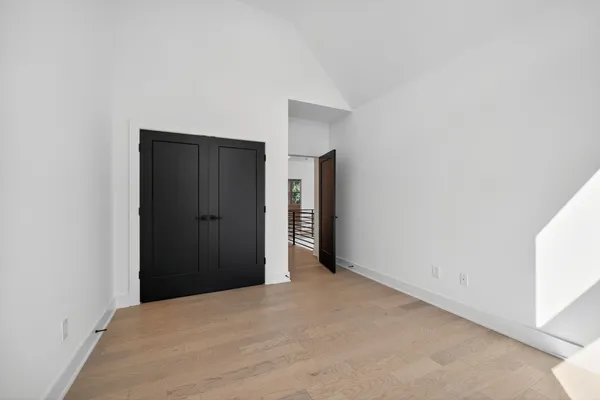 a view of an empty room with closet and a window