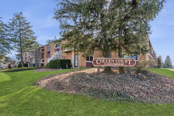 a sign board with a house in the background