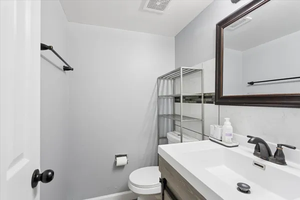 a bathroom with a sink toilet and mirror