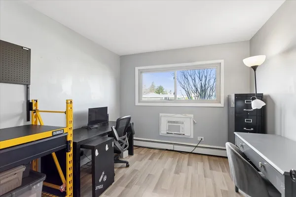 a view of a workspace with furniture and a window