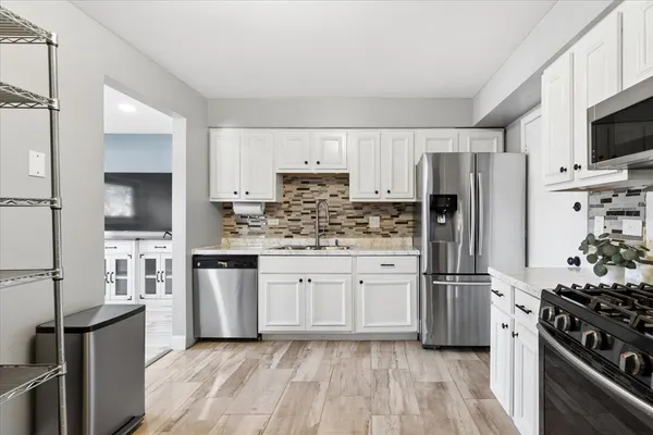 a kitchen with white cabinets and stainless steel appliances