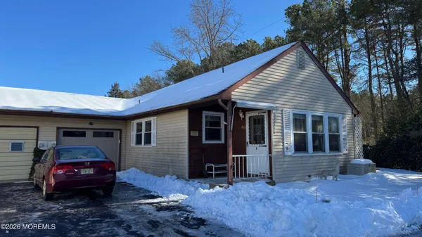 a view of a house with a cars park side of a road