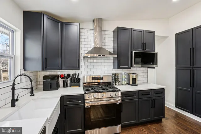 a kitchen with stainless steel appliances wooden cabinets a stove and a sink