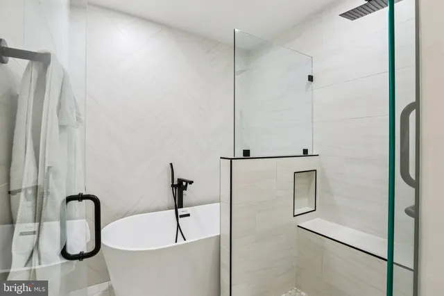 a bedroom with a bed a couch and a flat screen tv