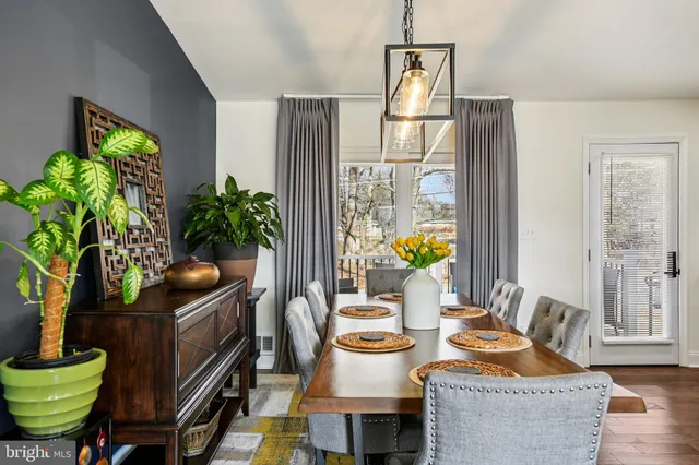 a dining room with furniture potted plants and wooden floor
