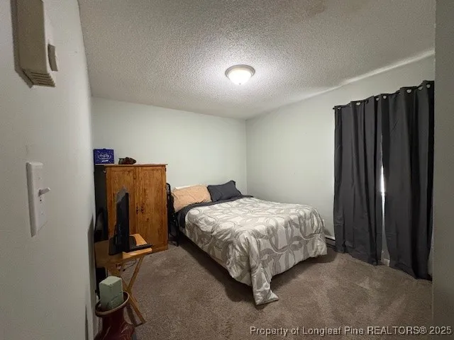 a bedroom with a bed and a refrigerator