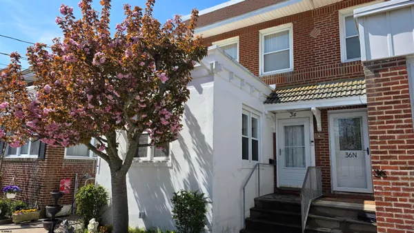 a front view of a house with a tree