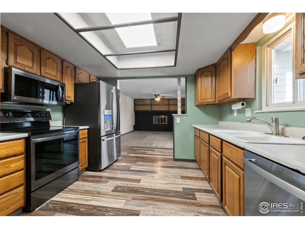 310 Apache Street Fort Morgan, CO 80701 - Photo 11 of 50 a kitchen with stainless steel appliances granite countertop a stove a sink and a microwave