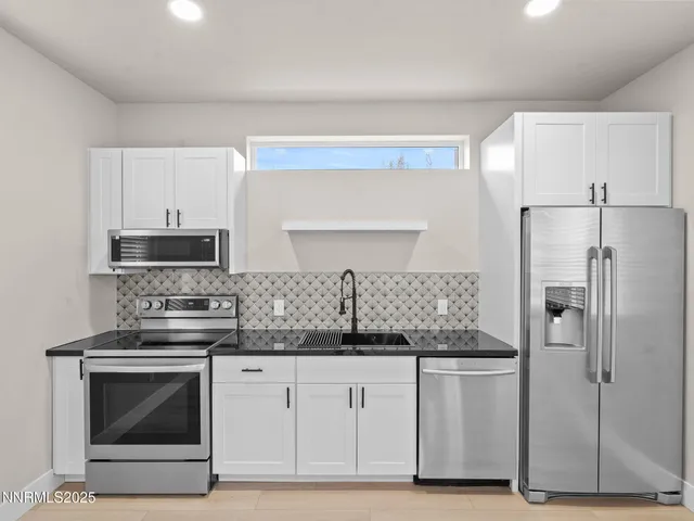 a kitchen with stainless steel appliances granite countertop a refrigerator and a stove