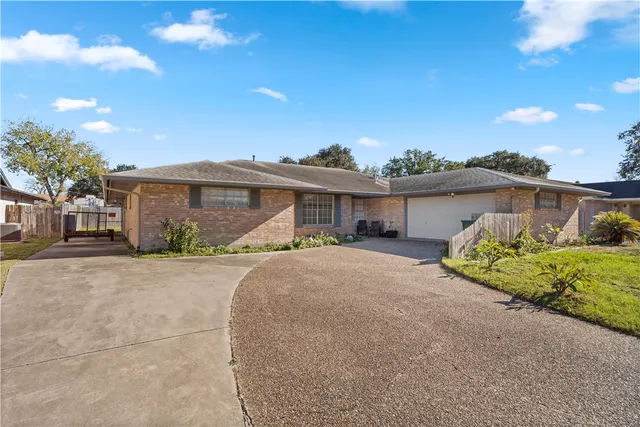 a front view of a house with a garden and yard