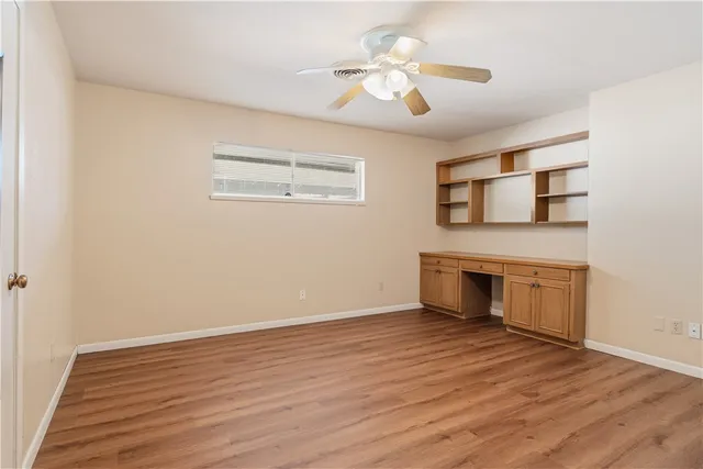 a view of an empty room with a fireplace and a window