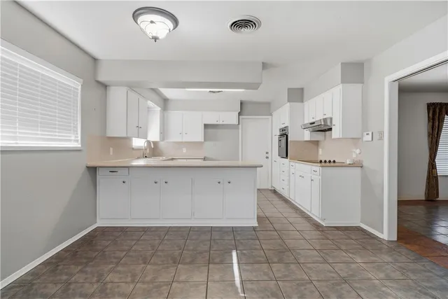 a kitchen with a sink window and cabinets