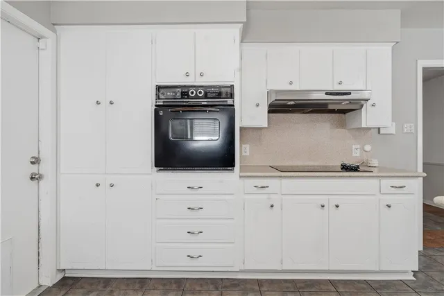 a kitchen with stainless steel appliances granite countertop a stove a microwave and a white cabinets