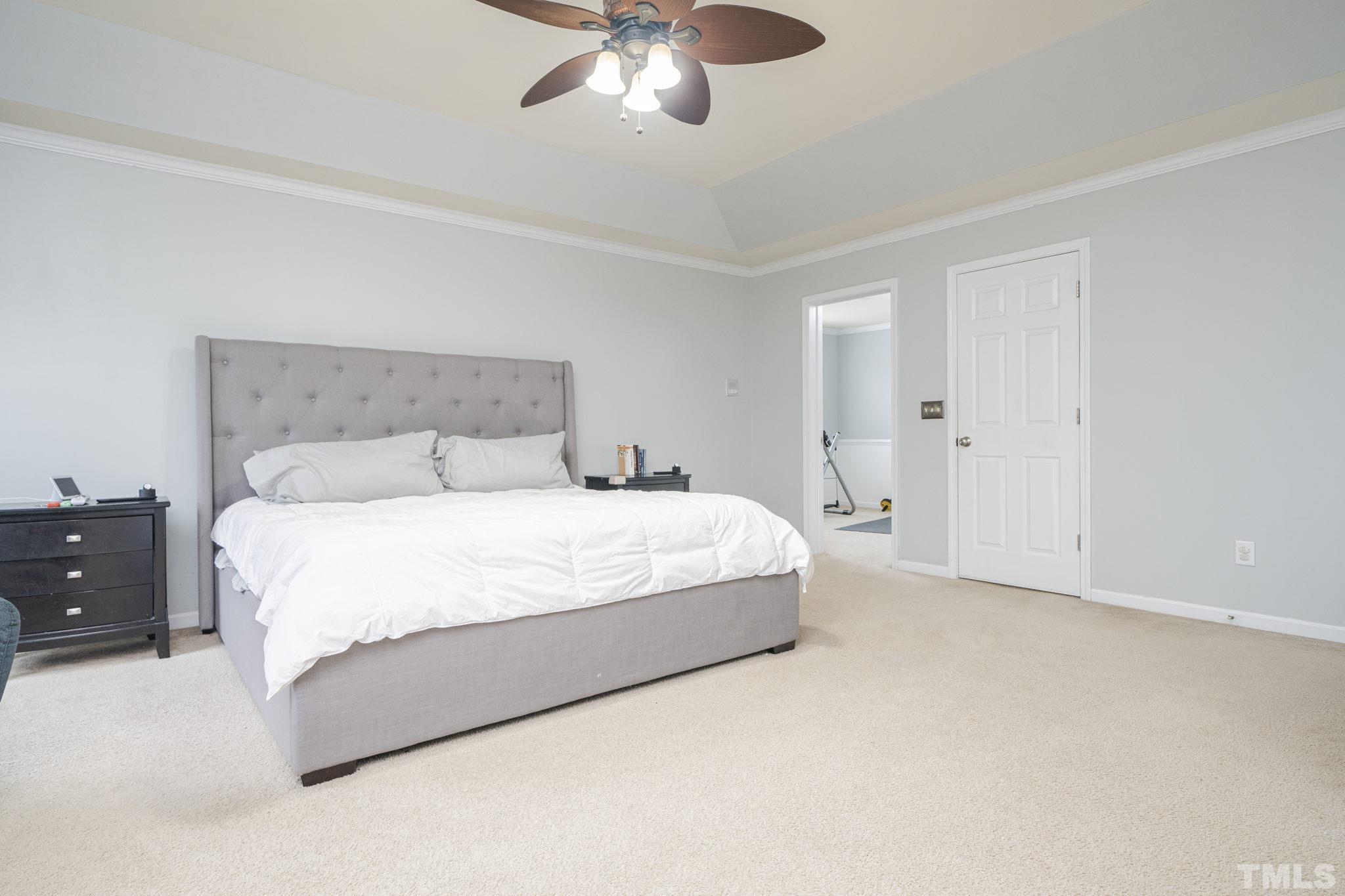 930 Pristine Lane Rolesville, NC 27571 - Photo 17 of 30 a spacious bedroom with a bed and a chandelier