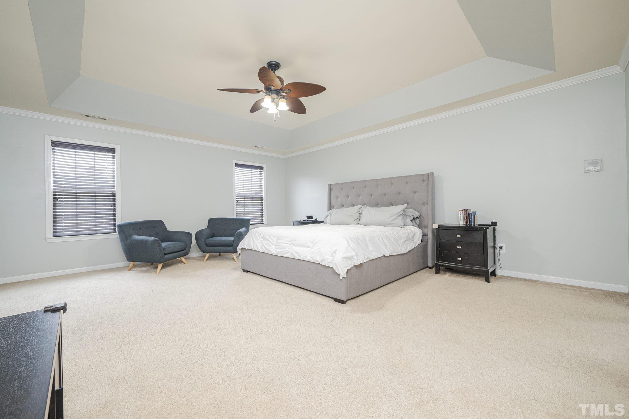 930 Pristine Lane Rolesville, NC 27571 - Photo 18 of 30 a spacious bedroom with a bed and a chandelier