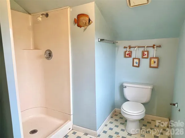 a bathroom with a toilet and a shower