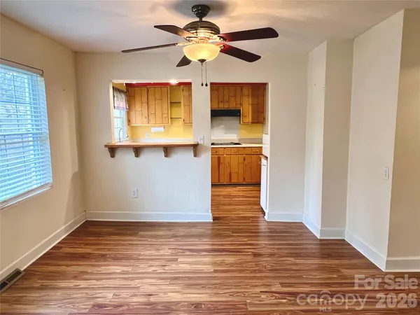 a view of empty room with window and wooden floor