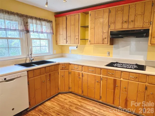 a kitchen with stainless steel appliances granite countertop a sink a stove and next to a window