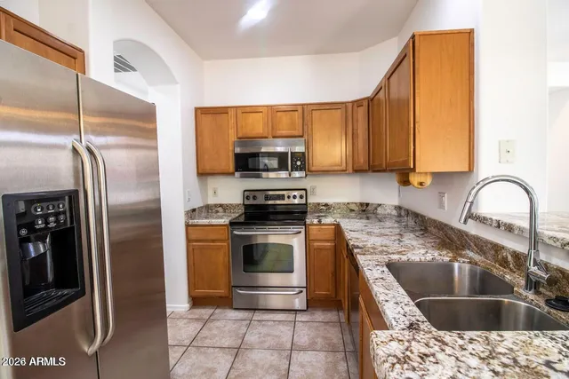 a kitchen with stainless steel appliances granite countertop a stove microwave and cabinets