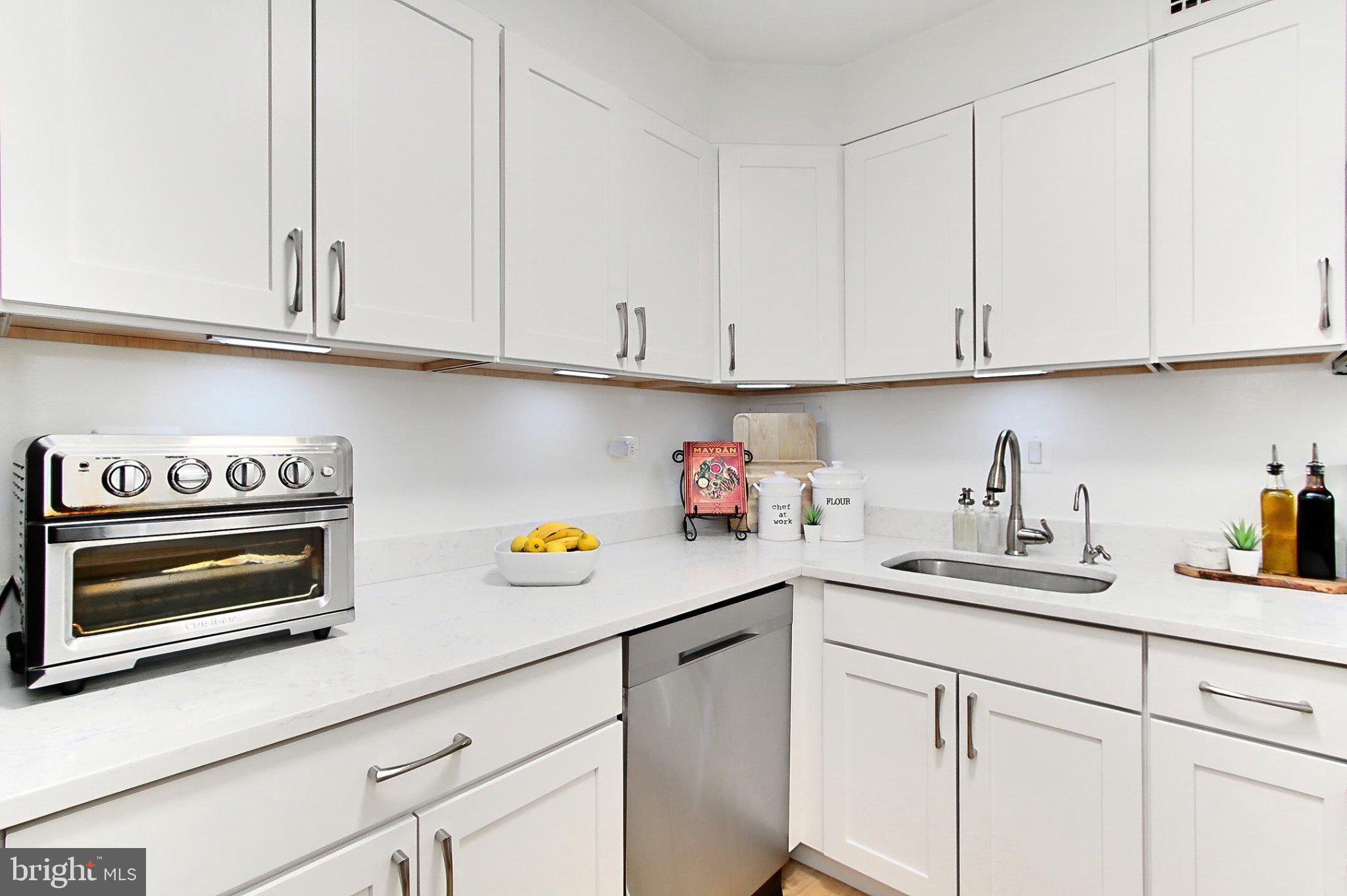 a kitchen with white cabinets and a sink