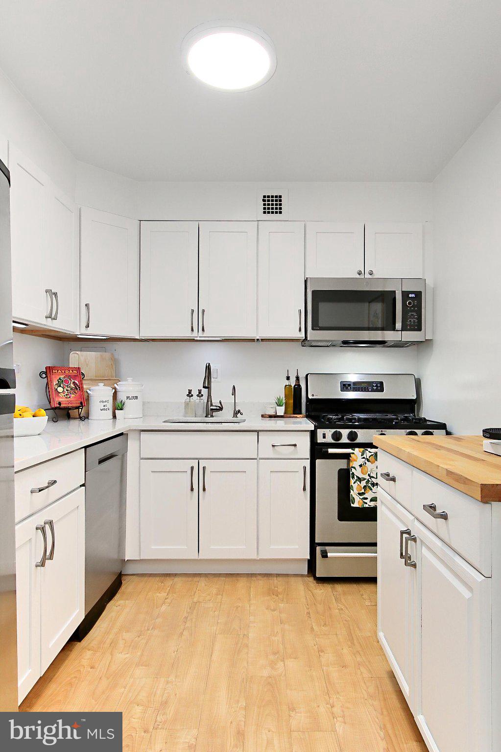 700 7th Street Southwest, Unit 730 Washington, DC 20024 - Photo 2 of 56 a kitchen with granite countertop a sink a stove and cabinets