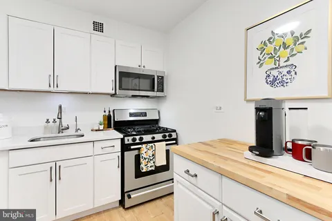 a kitchen with stainless steel appliances granite countertop a sink and a stove