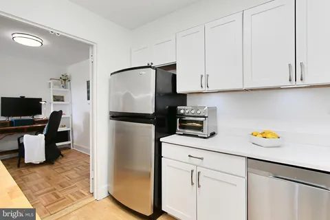 a kitchen with a refrigerator and cabinets
