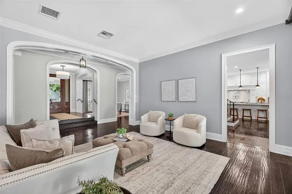 a kitchen with stainless steel appliances granite countertop a table chairs stove and wooden floor