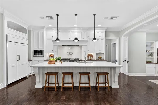 a kitchen with stainless steel appliances kitchen island granite countertop a stove a sink a dining table and chairs with wooden floor