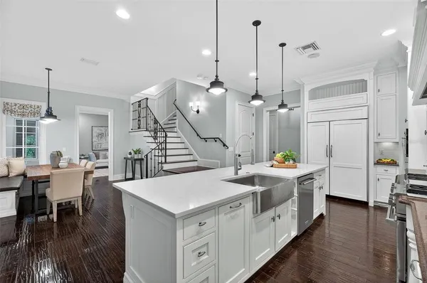 a dining room with wooden floor a chandelier a wooden table and chairs