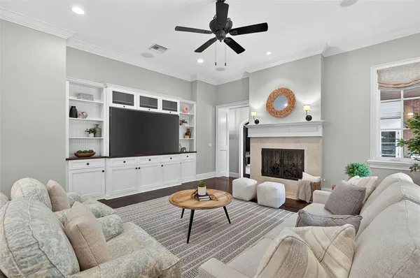 a living room with furniture a flat screen tv and a refrigerator