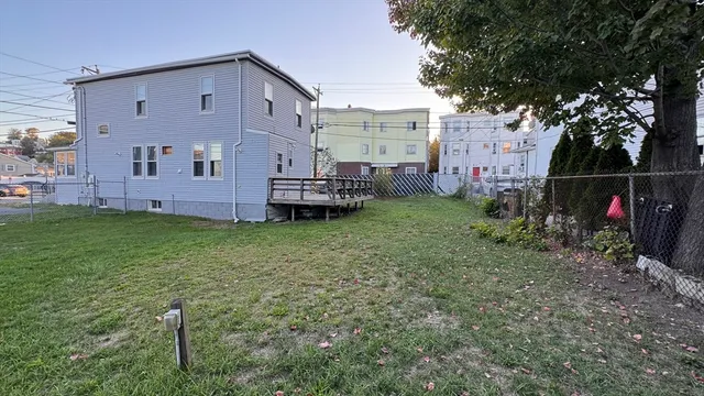 a view of a house with backyard and trees