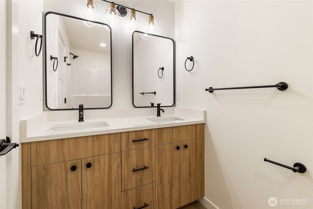 a bathroom with a double vanity sink a mirror and shower