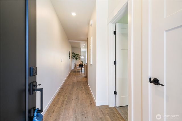a view of a hallway with wooden floor and staircase