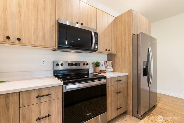 a kitchen with stainless steel appliances white cabinets and a stove top oven