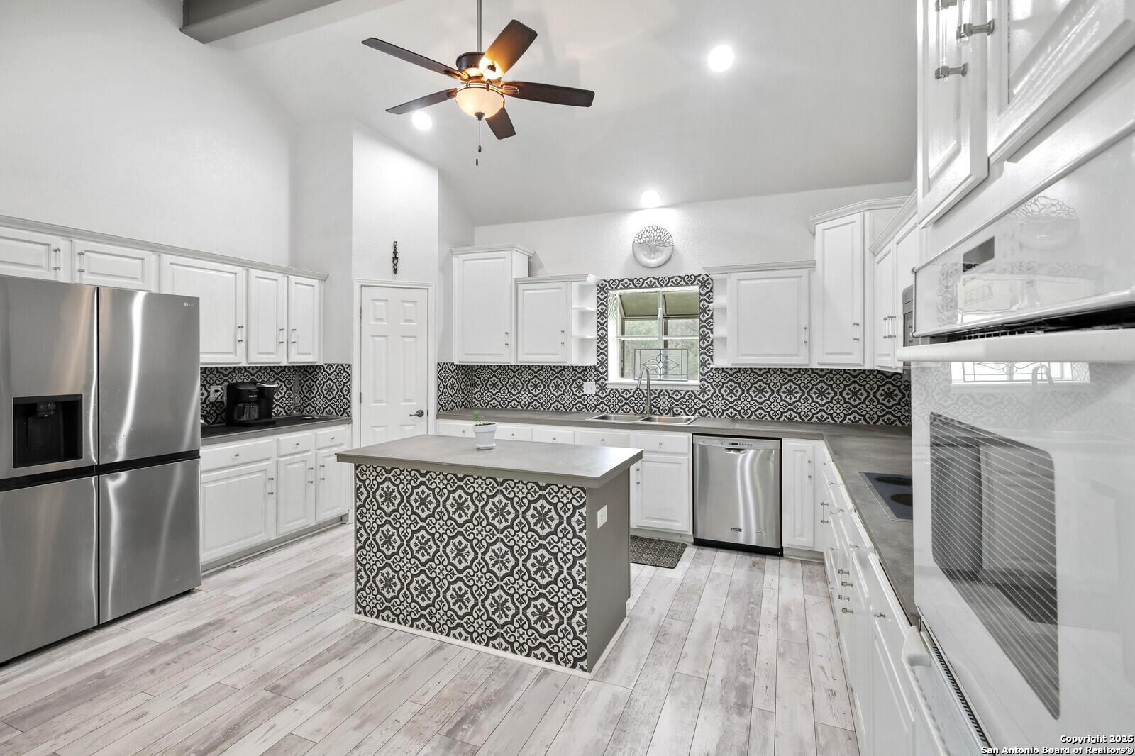 341 Indigo Run Drive Bulverde, TX 78163 - Photo 16 of 37 a kitchen with a refrigerator a sink and dishwasher a oven with wooden floor