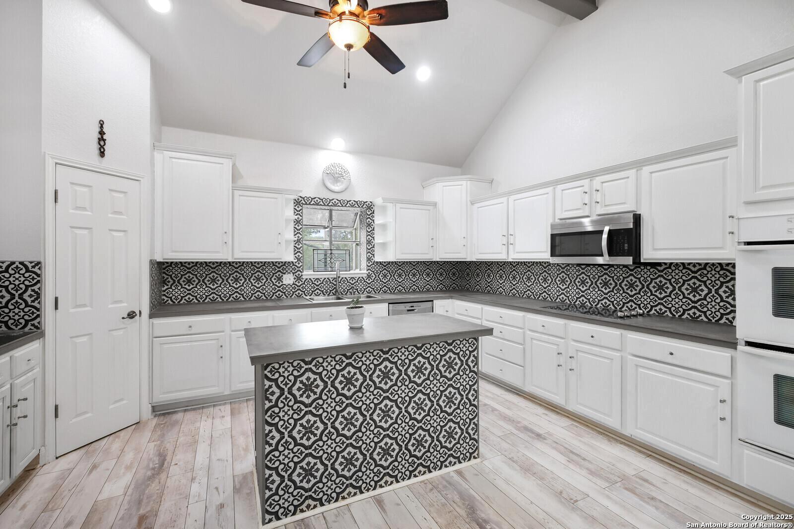 341 Indigo Run Drive Bulverde, TX 78163 - Photo 17 of 37 a kitchen with stainless steel appliances granite countertop a sink and cabinets