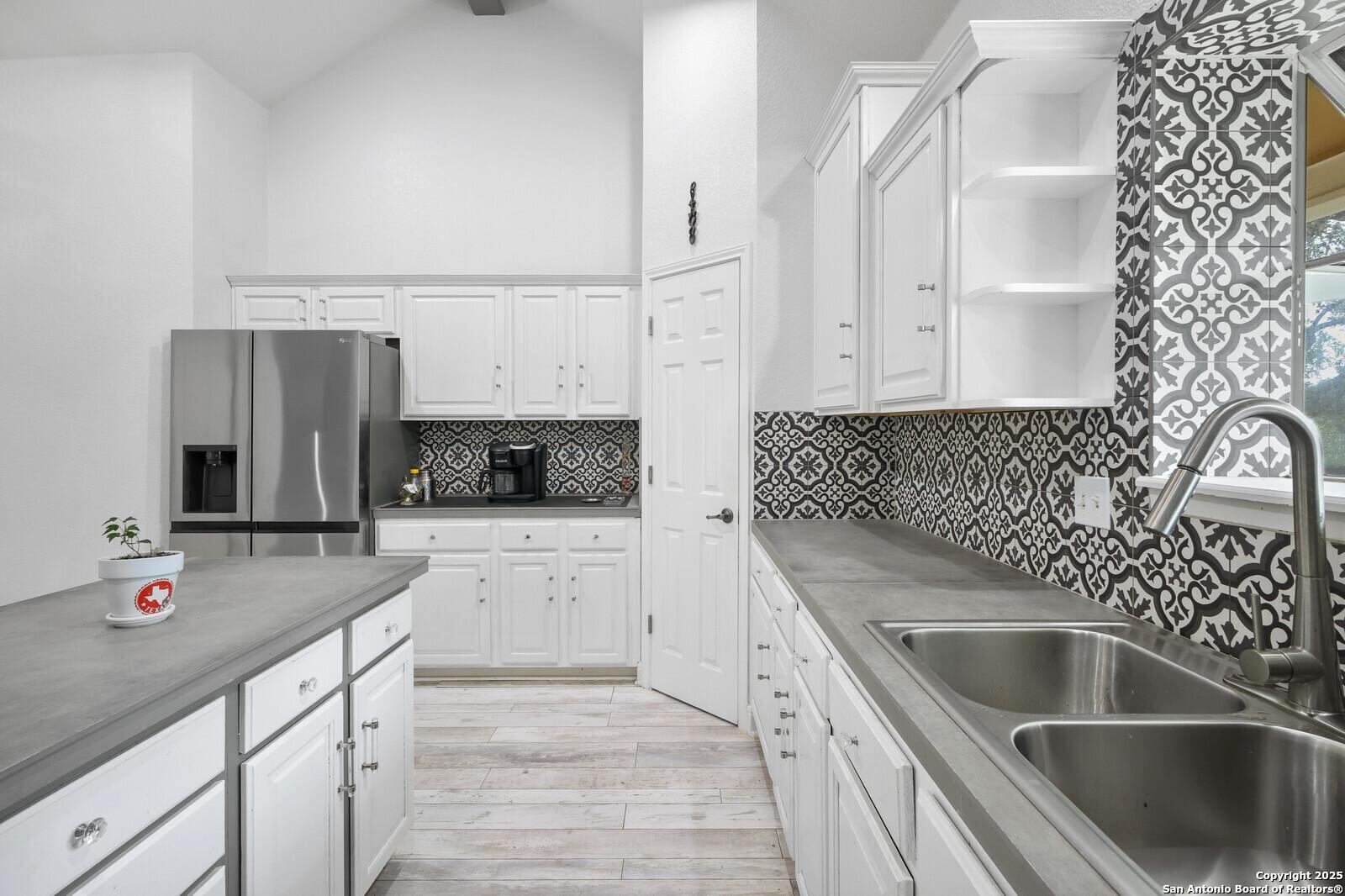 341 Indigo Run Drive Bulverde, TX 78163 - Photo 19 of 37 a kitchen with granite countertop a sink stove and cabinets