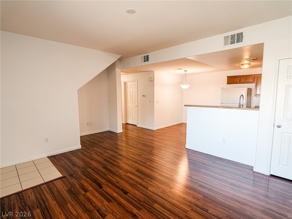 7701 West Robindale Road, Unit 110 Las Vegas, NV 89113 - Photo 8 of 21 Rich hardwood-style flooring flows seamlessly through this welcoming open-concept living space and kitchen.
