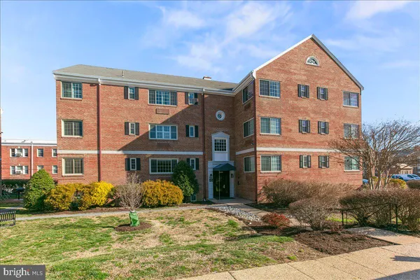 a front view of a house with garden and trees